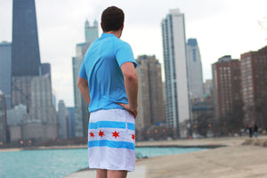 Chi Chi Sport lightweight athletic shorts featuring the Chicago flag design, worn by a man overlooking the city skyline
