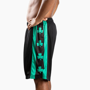 Chi Chi Sport men's black basketball shorts with green side panels featuring shamrock patterns and a 10-inch inseam.